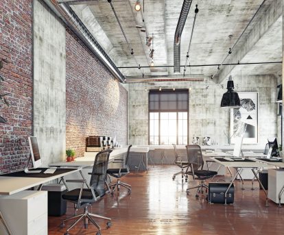 Modern co-working office space with exposed brick walls and concrete ceilings
