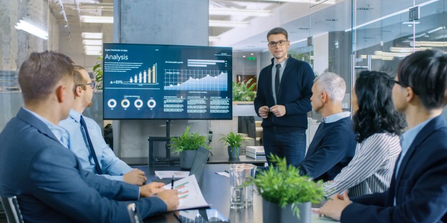 Young man presenting market research results to a group of five businesspeople