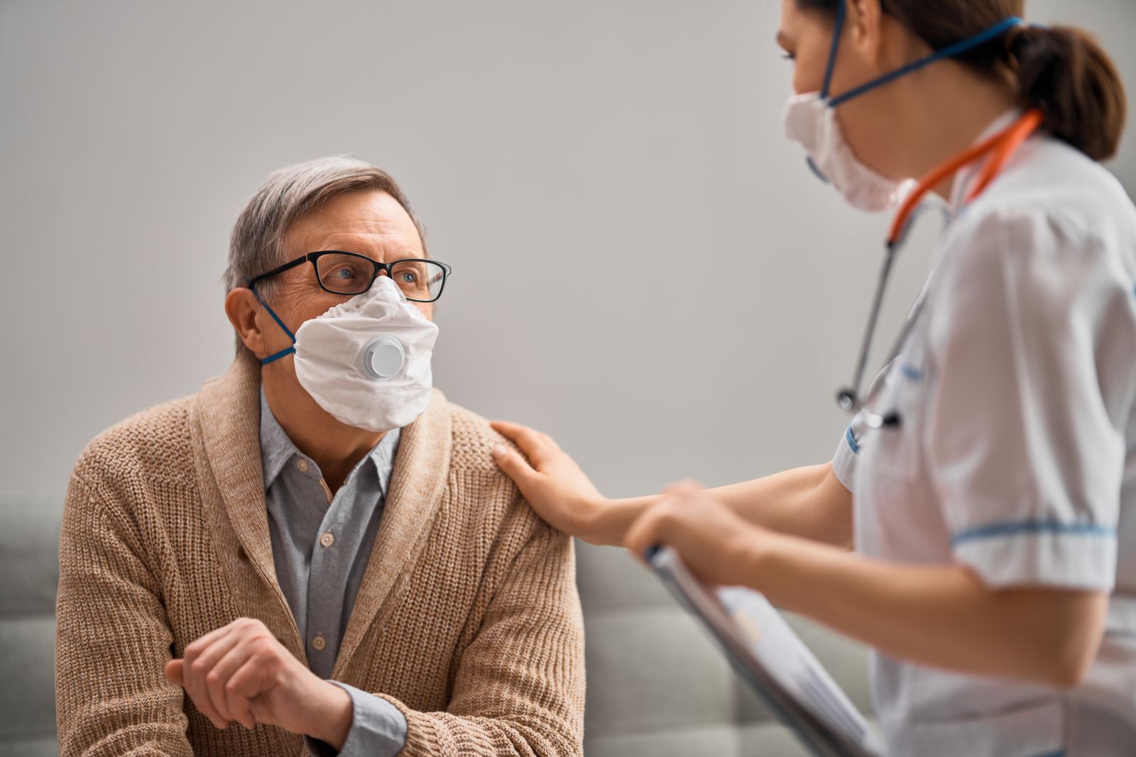 Patient and doctor talking while wearing facemasks