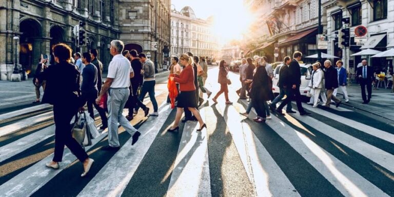 Crowd of people walking across a zebra crossing