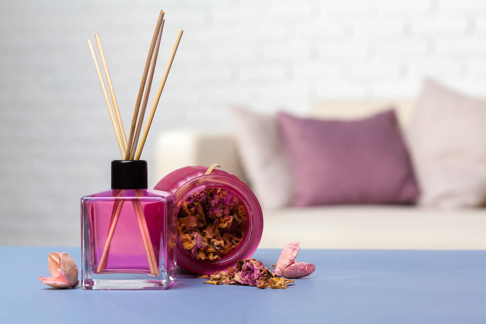 Close up of room scent sticks in a pink glass bottle domestic setting