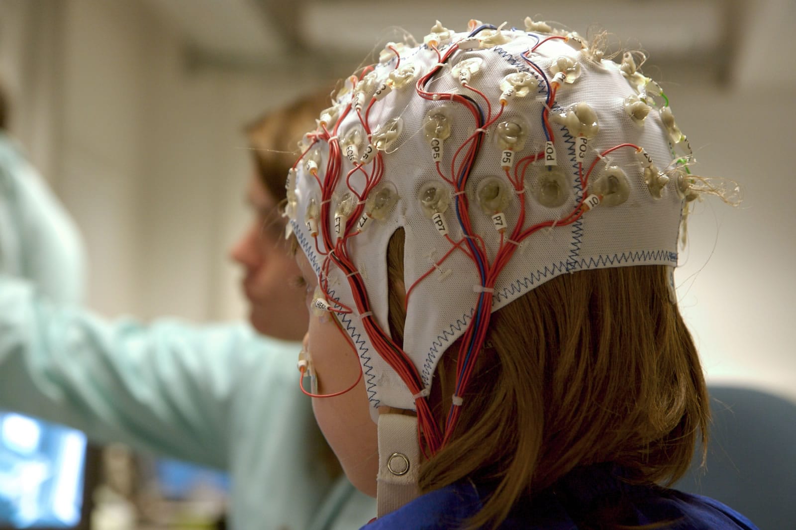 Research participant wearing brainwave monitoring cap with cables attached for neuroscience market research
