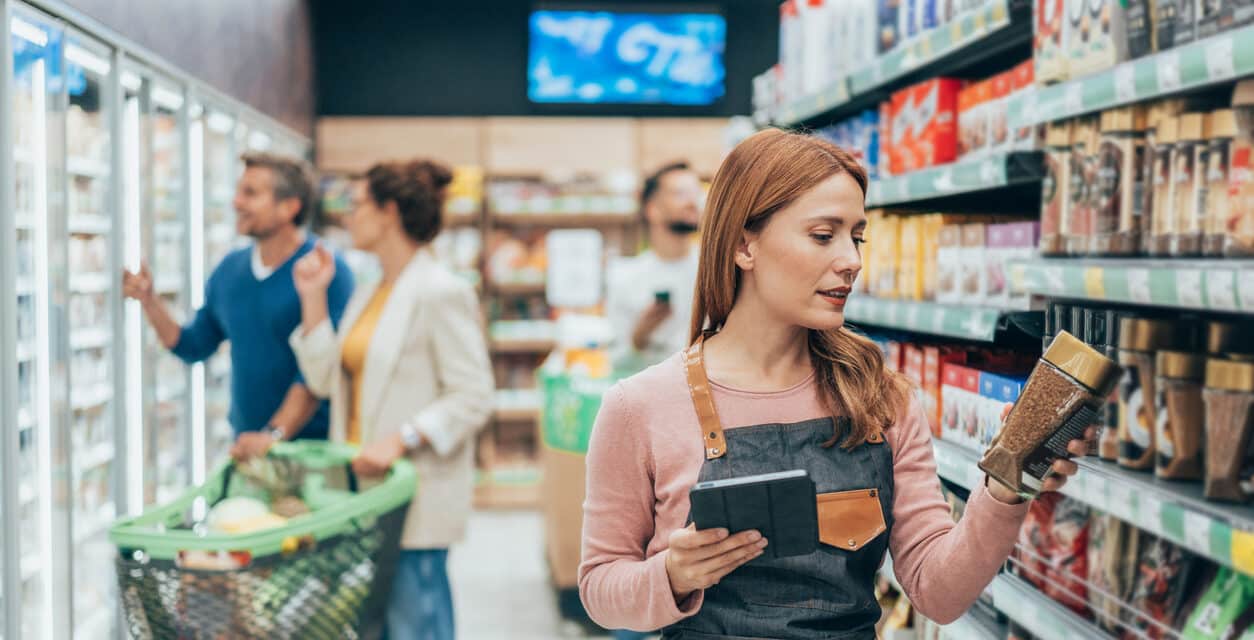 A woman looks at instant coffee while shopping in a supermarket
