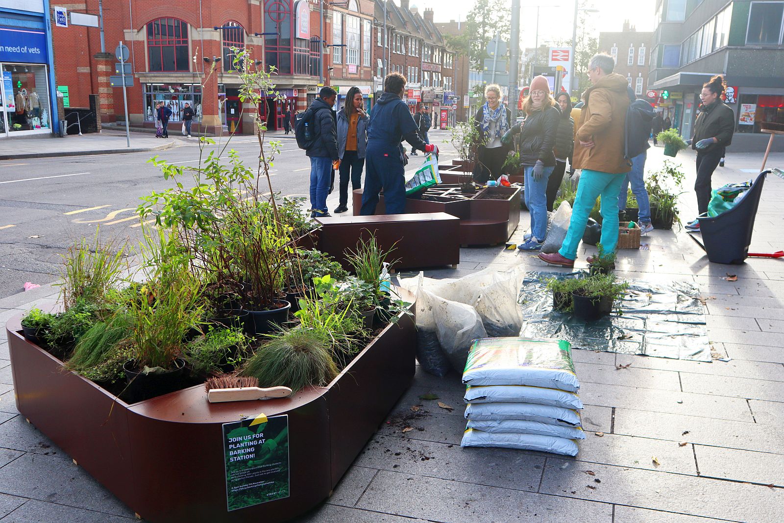 Group of volunteers filling new planters outside Barking station