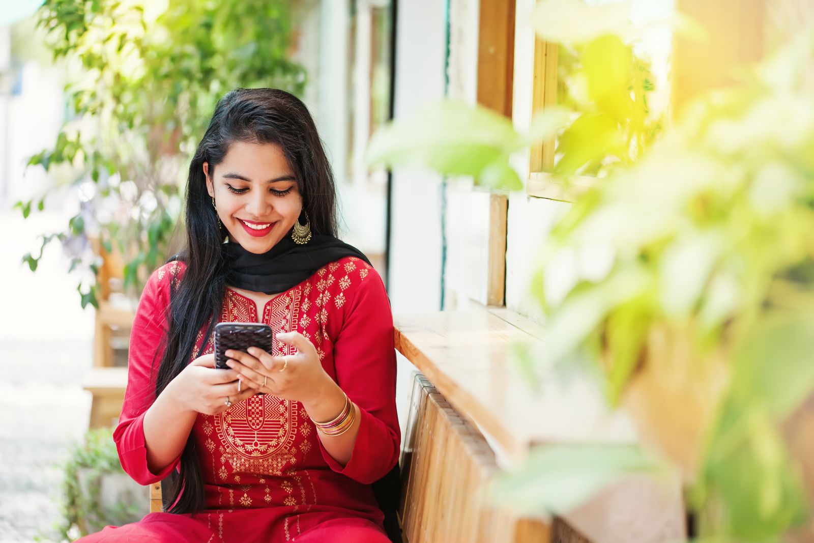 Young Indian woman visiting app store on her smartphone