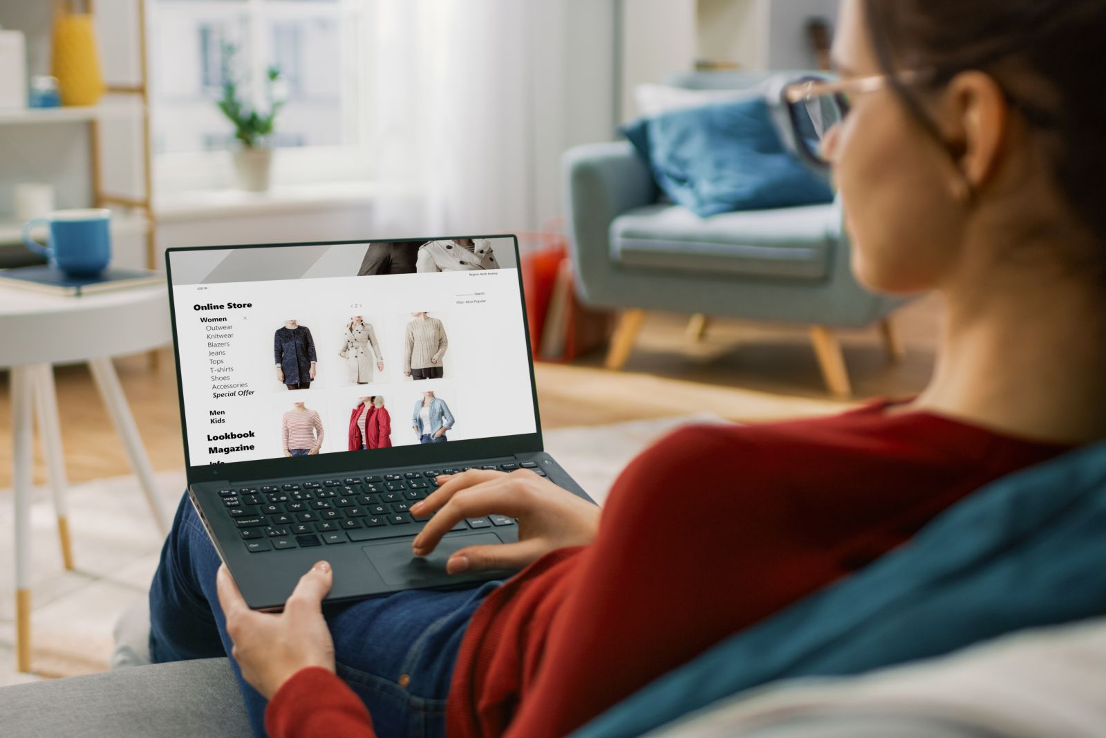 Woman sitting on a sofa at home ordering clothes online using a deferred payment option
