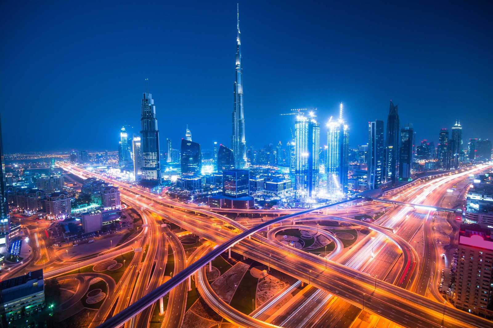 Dubai skyline at night with big highway junction in foreground