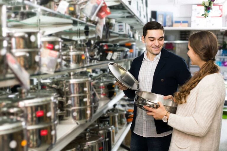 couple choosing new pan cookware set in kitchenware store