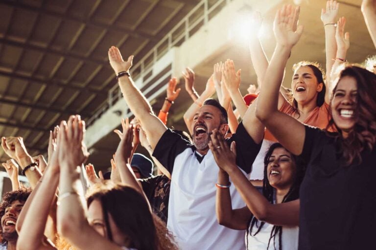 crowd of sports fans standing in football stadium cheering