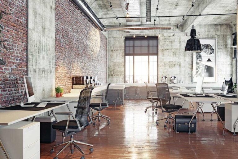 Modern co-working office space with exposed brick walls and concrete ceilings