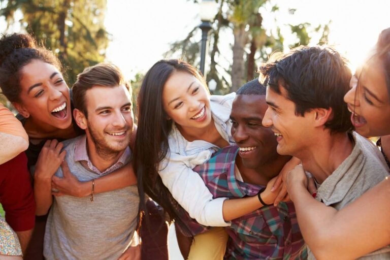 Respondent verification concept - a diverse group of young people smile and hug each other outdoors