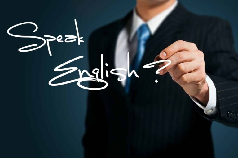 Speaking English concept - a man writes 'Speak English?' in white pen on a glass window