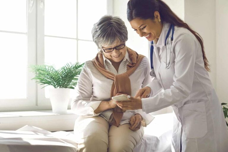 doctor teaches patient how to use health monitoring device