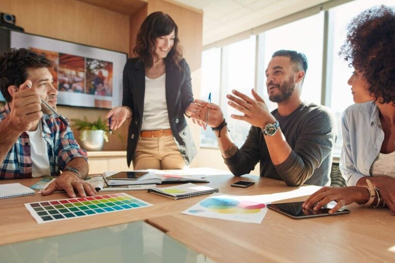 team of ad agency staff taking part in brainstorming session in modern meeting room
