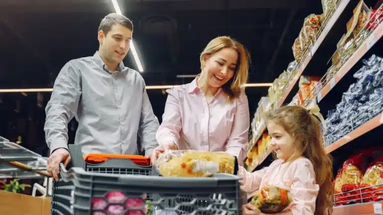 Mother, father and daughter with shopping trolley in a supermarket