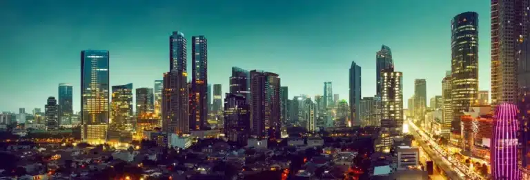 Jakarta, Indonesia - city skyline at dusk with tall buildings and a busy highway stretching into the distance