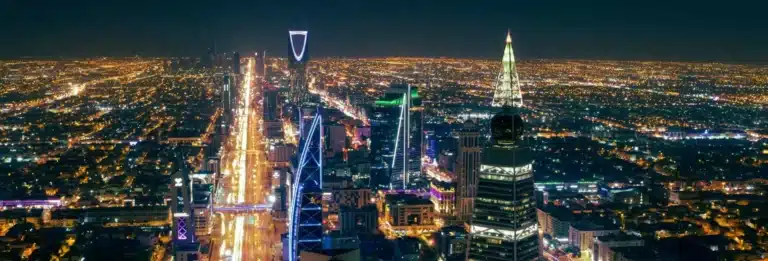 Riyadh, Saudi Arabia - cityscape at night with a busy road stretching into the distance and several illuminated skyscrapers visible in the foreground