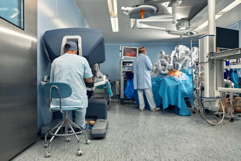 surgeon using da vinci robotic system in hospital operating theatre on a patient