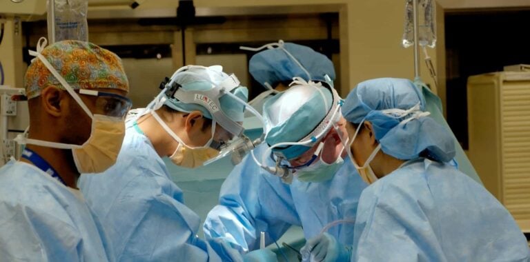 Group of healthcare professionals performing a procedure in an operating theatre