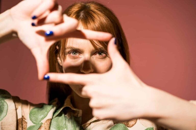 Online focus group concept - Young woman forms a rectangle by holding her hands up in front of her face