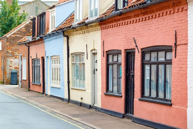 colourful english holiday home cottages for leisure travellers in seaside town on a sunny day