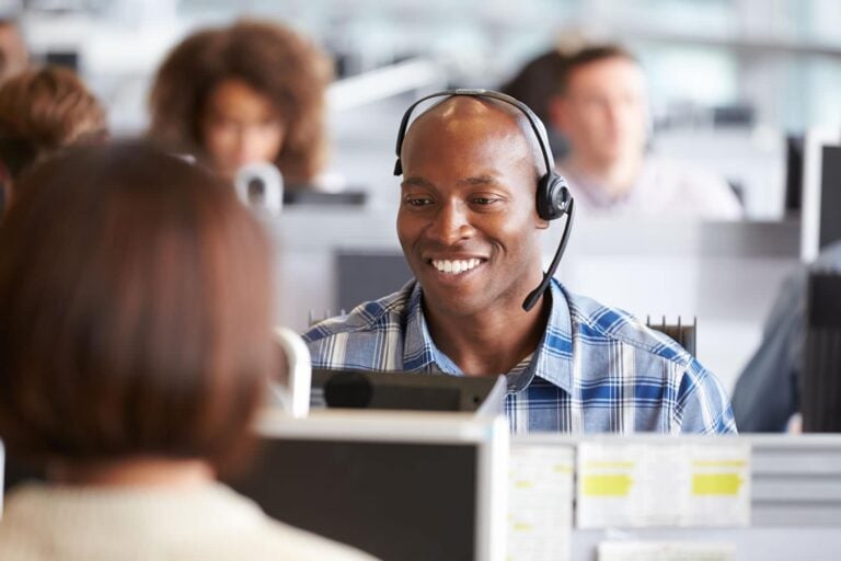 man working in UK call centre with headset and computer