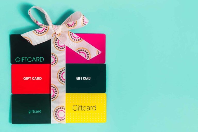 gift cards laid out on teal background with decorative ribbon tied in a bow