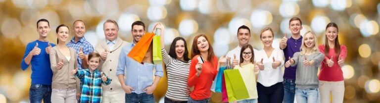 Group of consumers holding brightly coloured shopping bags and giving thumbs up