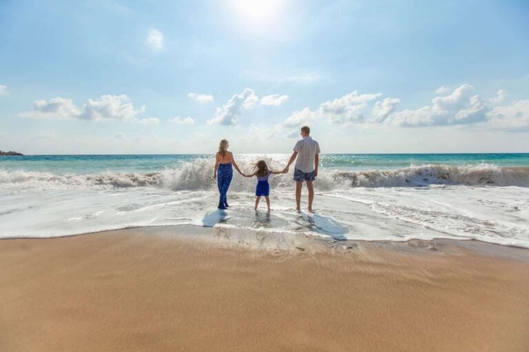 Man with woman and daughter on a sunny beach while on holiday