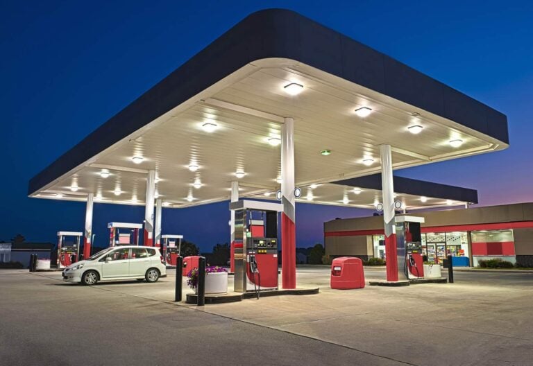 petrol station at dusk with car on forecourt and retail shop