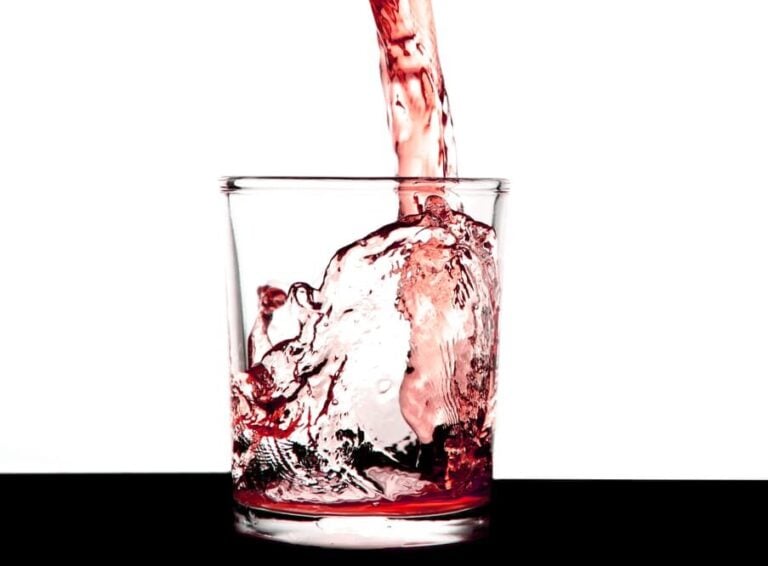 Pouring diluted squash into a glass tumbler