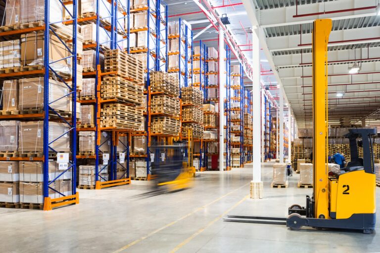 large modern warehouse with forklifts and packages being shipped