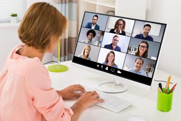 Woman moderating an online focus group with 9 B2B participants visible on a computer screen