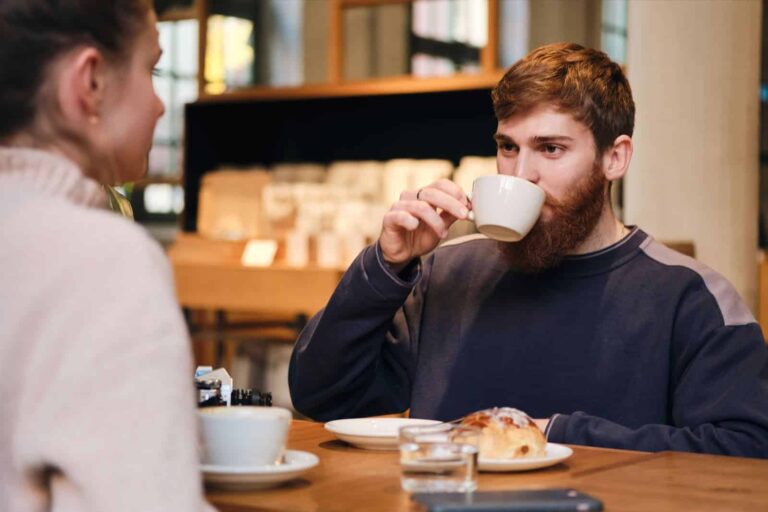 freelancer drinking coffee in berlin cafe while chatting to colleague