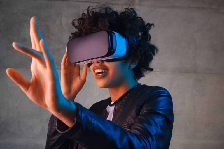woman wearing virtual reality goggles and reaching out left hand in amazement in VR world