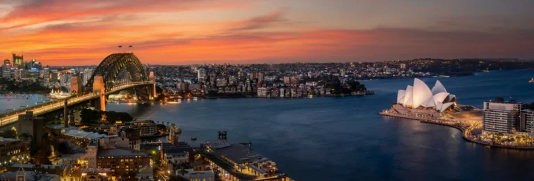 Sydney, Australia - skyline at sunset with Sydney Harbour Bridge and Sydney Opera House visible in the foreground