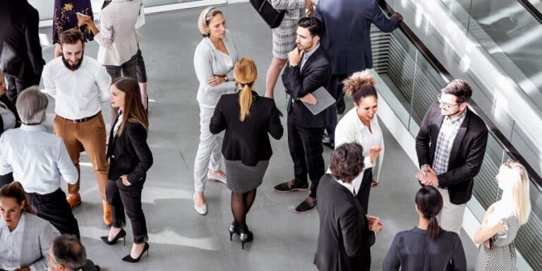 A group of business people standing and chatting in informal groups, viewed from above