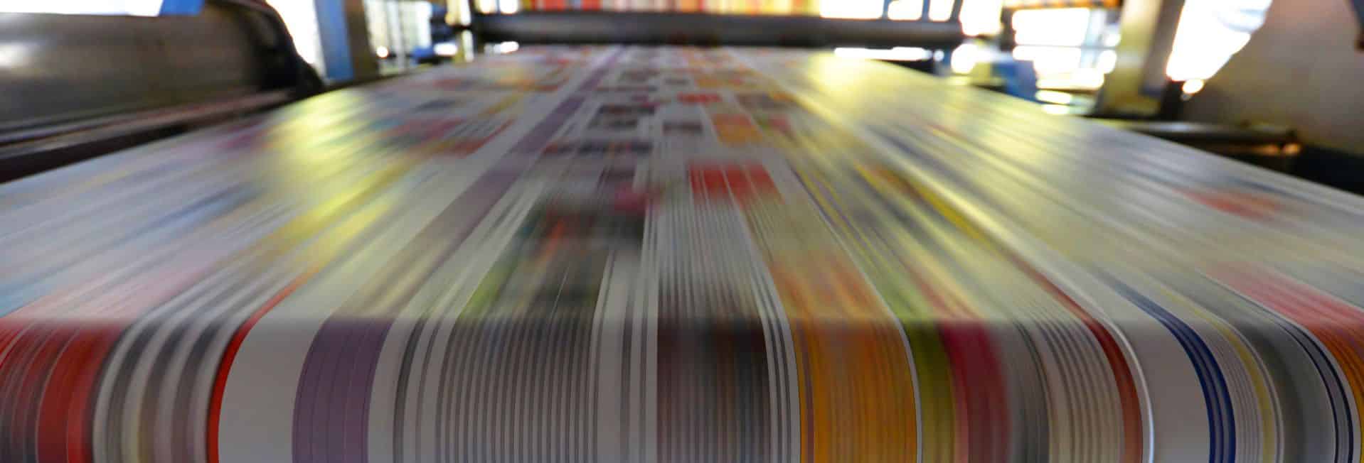 Close up of high-speed offset printing press printing news stories