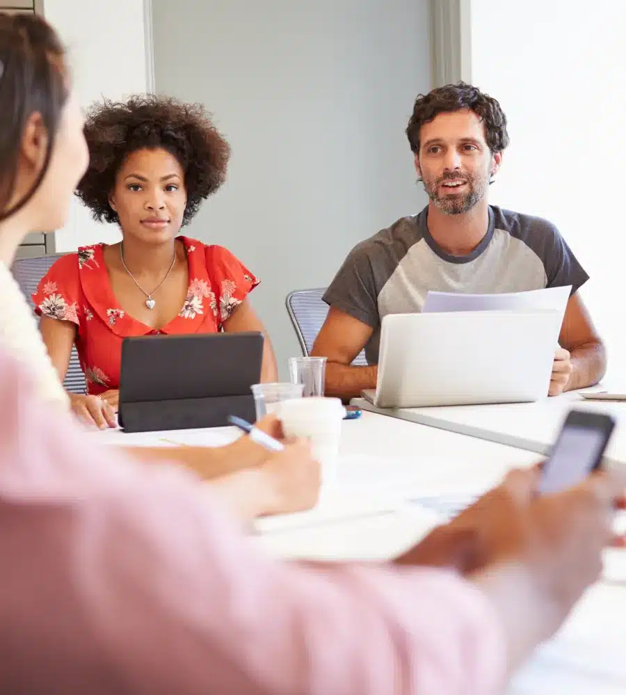 Multi-ethnic group of market researchers sitting in a meeting room discussing a new project