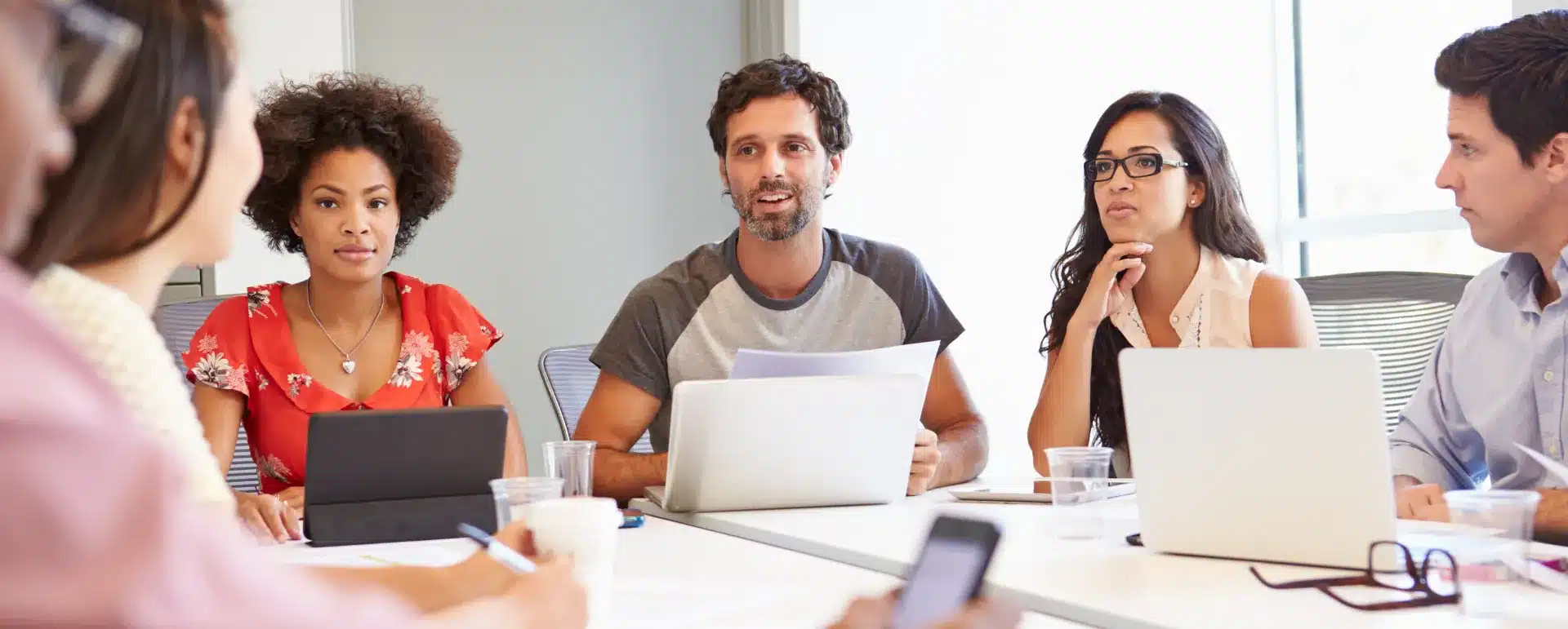 Multi-ethnic group of market researchers sitting in a meeting room discussing a new project