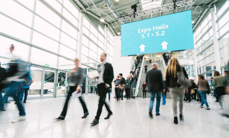 expo attendees walking through IT conference booth exhibition hall united states