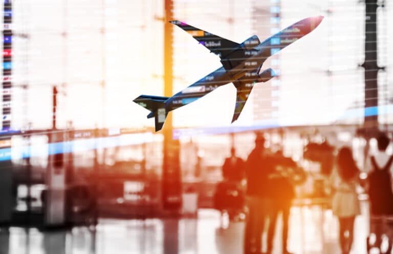 plane of international airline flying past window at the airport with passengers walking through terminal