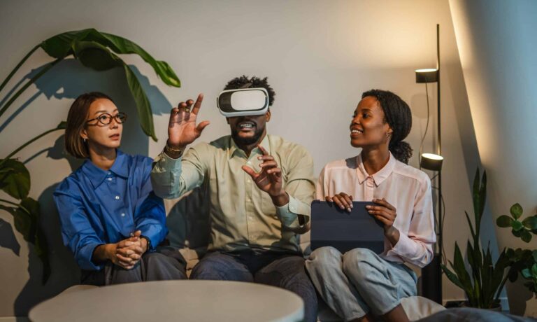 Two researchers conducting an in-home ethnography with a young man wearing a VR headset