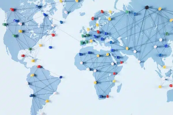 Global network concept - push pins linked by threads in a map of the world